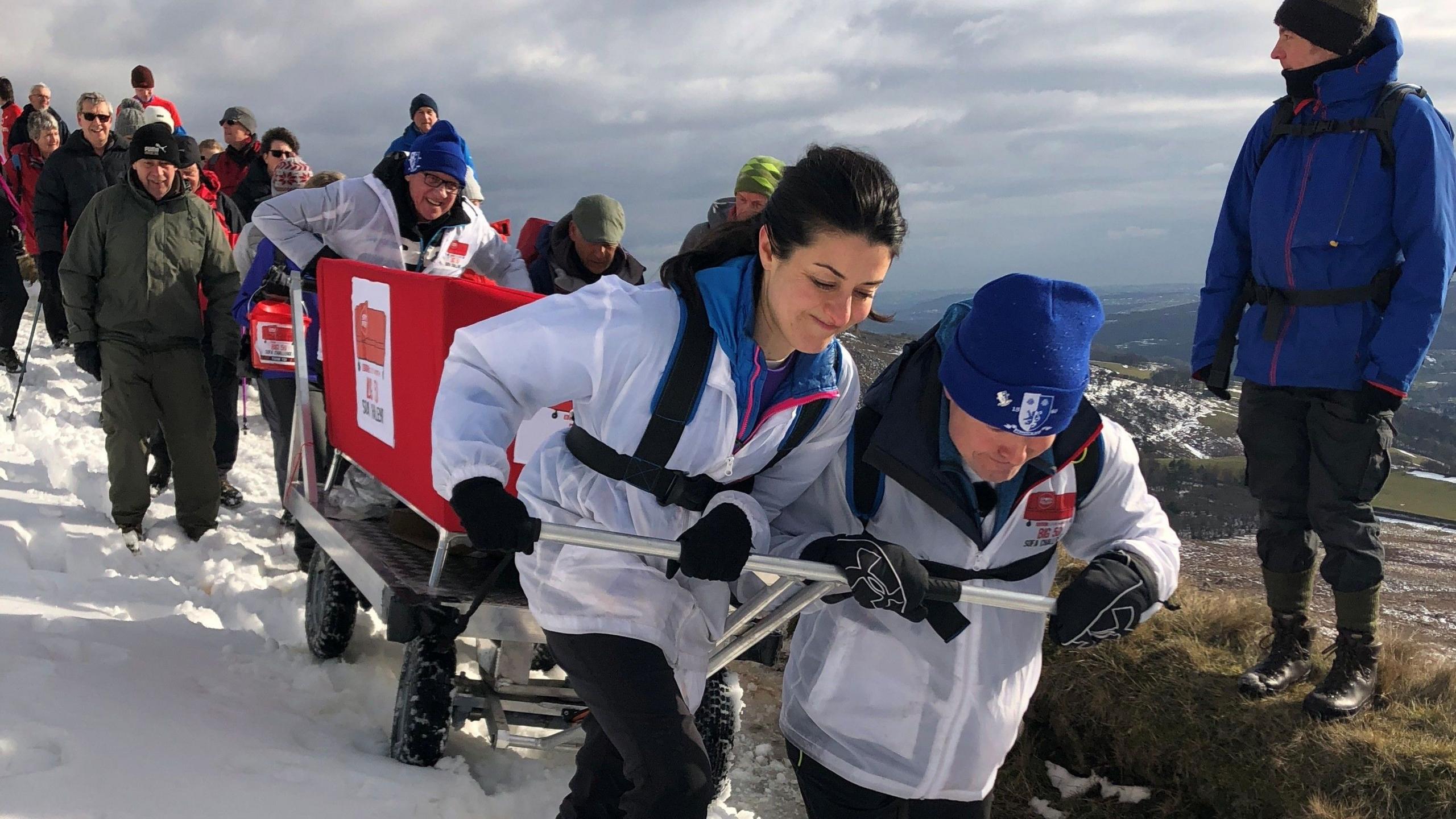 Amy Garcia, Paul Hudson and Harry Gration pull the Look North red sofa through snow during the 2018 challenge