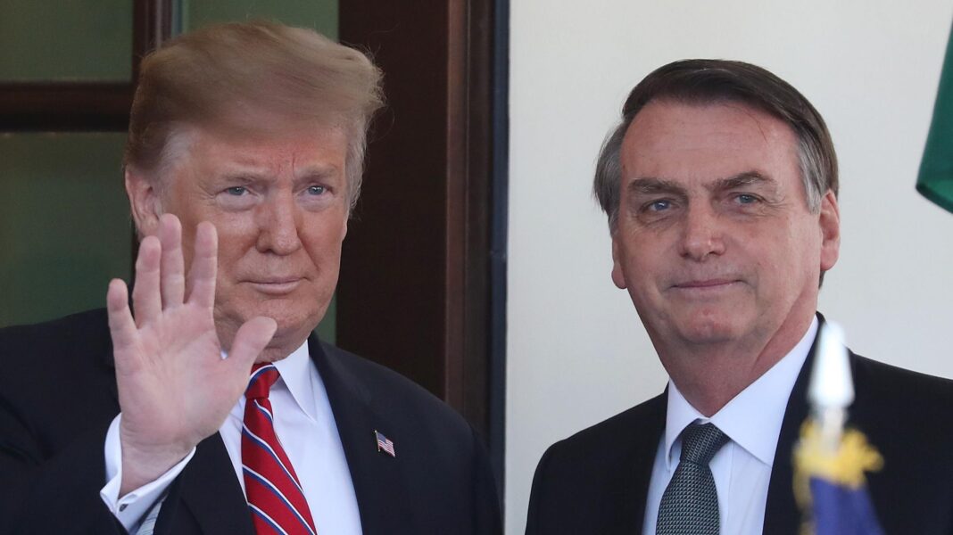 Trump, with a waving hand, stands next to Bolsonaro outside the White House.