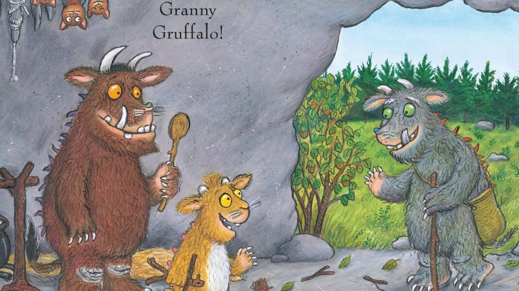 An illustration featuring the brown Gruffalo holding a wooden spoon next to a smaller creature inside a cave, looking towards a grey, furry character with a walking stick at the entrance.