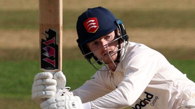 George Bell, wearing an Essex Cricket helmet, swings his bat during a match.
