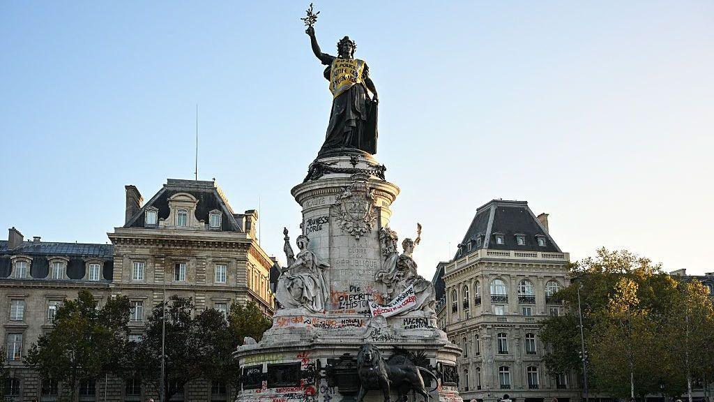 The vandalised Monument a la Republique, which has been covered with a yellow vest