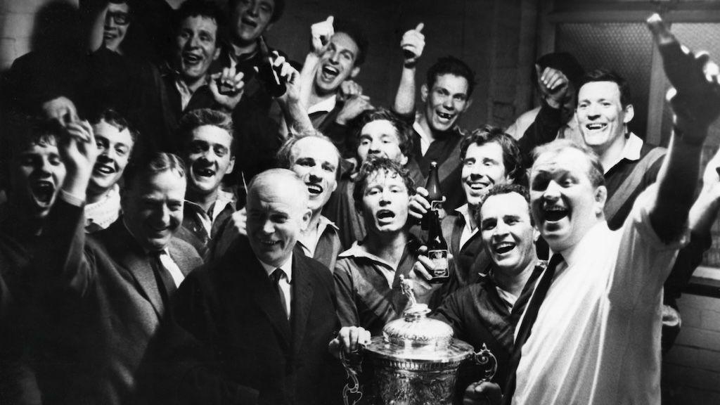 Wakefield's Championship winning side of 1967 poses with the trophy in the dressing room while clutching bottles of beer and other alcohol as a celebration