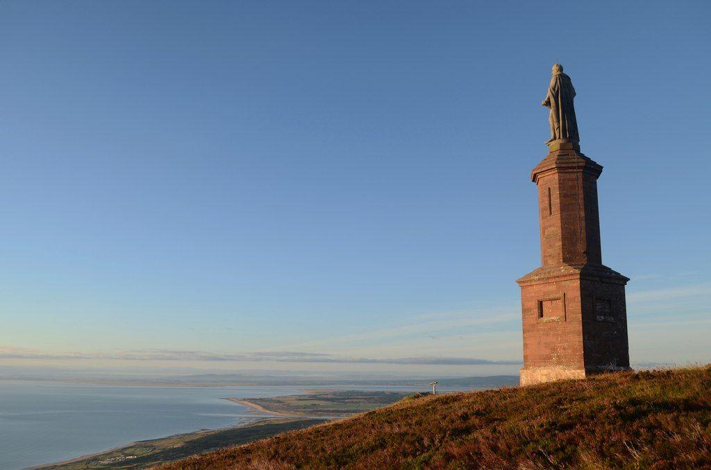 Monument to the Duke of Sutherland. The monument is a stone tower-like structure with a statue of the duke on top.
