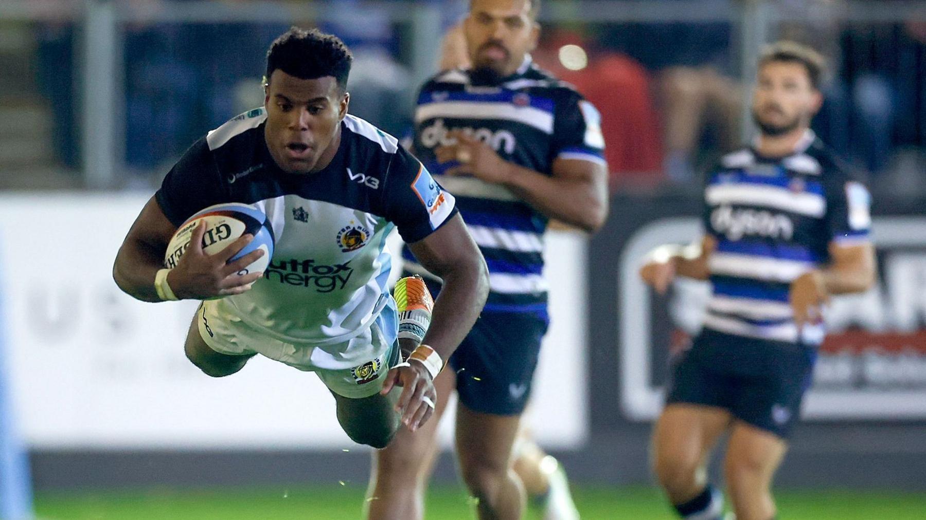 Immanuel Feyi-Waboso swallow dives as he scores a try for Exeter with two Bath players trailing behind him