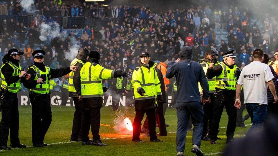 Fans from both sides ran on to the pitch at Ibrox in March