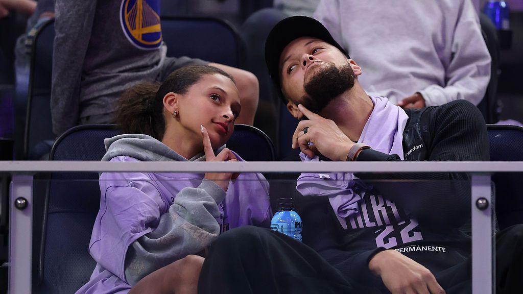Steph Curry and his daughter pose for the cameras at a basketball game