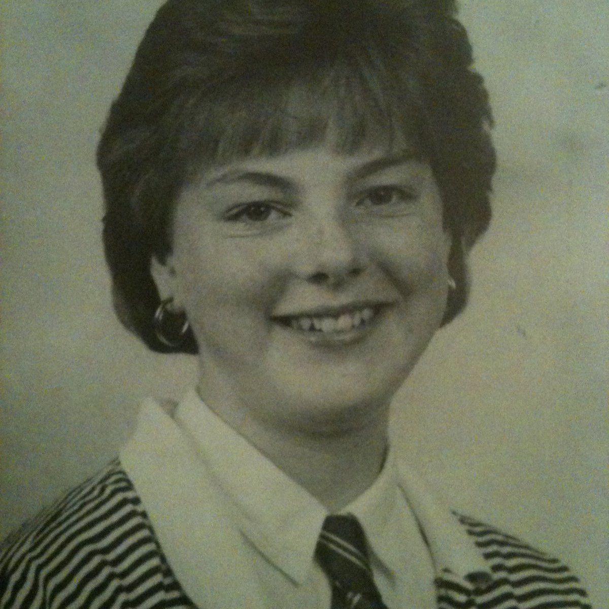 Black-and-white school portrait showing Diane Watson with short hair wearing a striped blazer, white shirt and striped tie, facing the camera against a plain studio background.