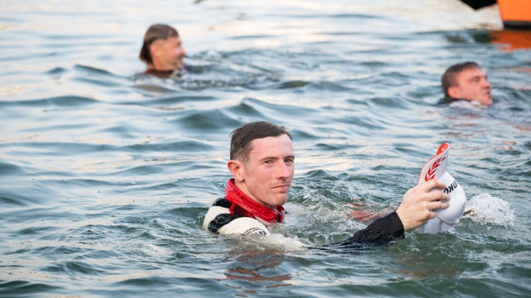 How Britain’s Evans defied history to join rallying greats Elfyn Evans in full overalls in the sea holding his hat