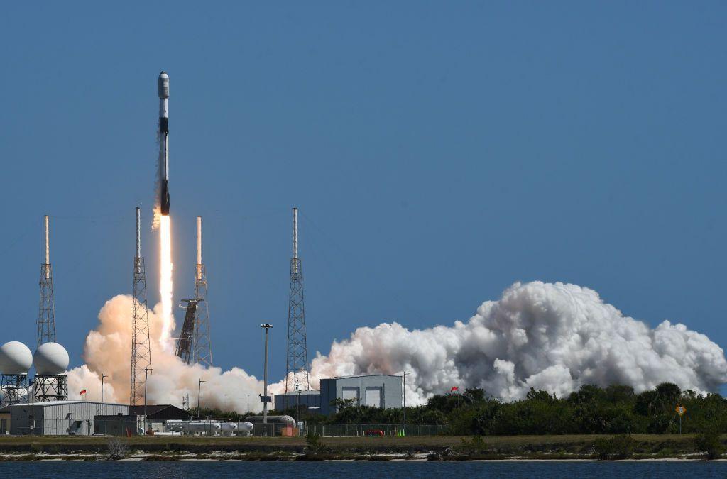 A rocket taking off, with heavy smoke around the base.