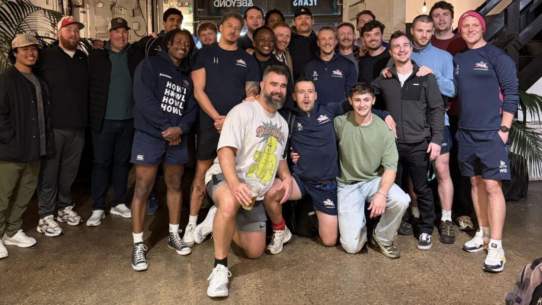 ‘Ran through me’ & ‘good value in pub’ – ex-NFL star Kelce tries rugby Jason Kelce kneels on floor in front of group shot of Old Street team in London pub.