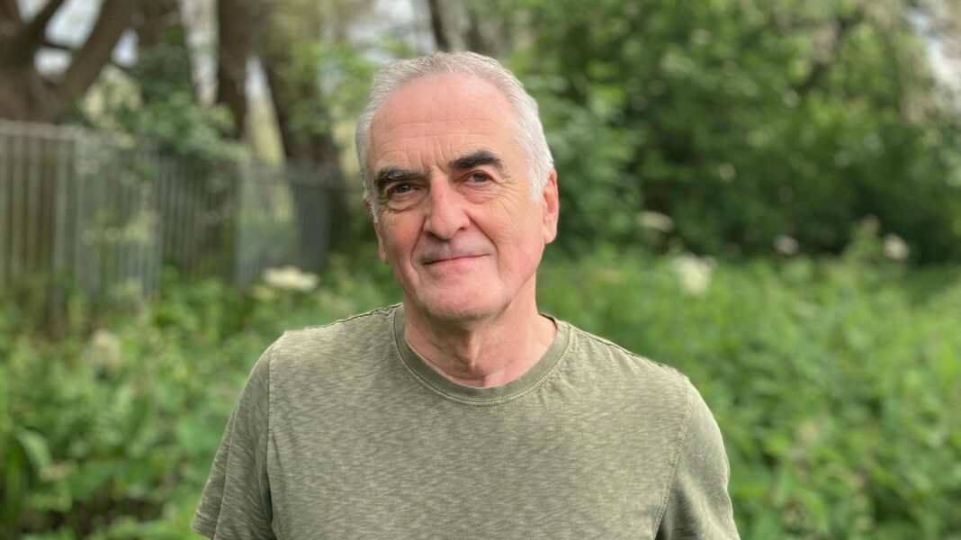 Water system a ‘disaster’, Green deputy leader says Ash Smith looking at the camera - he's got white hair, black eyebrows and is wearing a green T-shirt. He's white.
