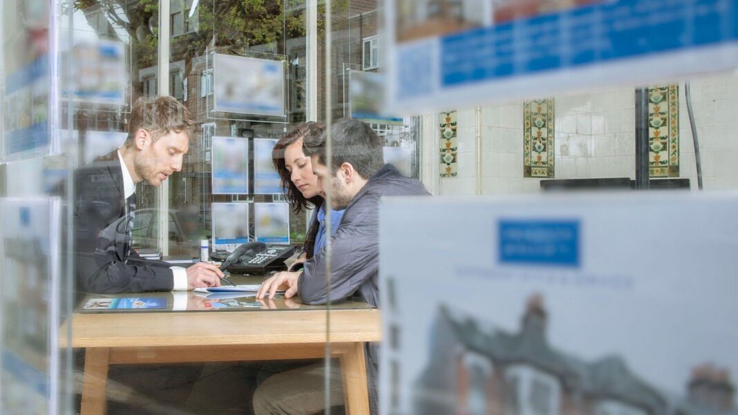 Couple buying a home in an estate agent.