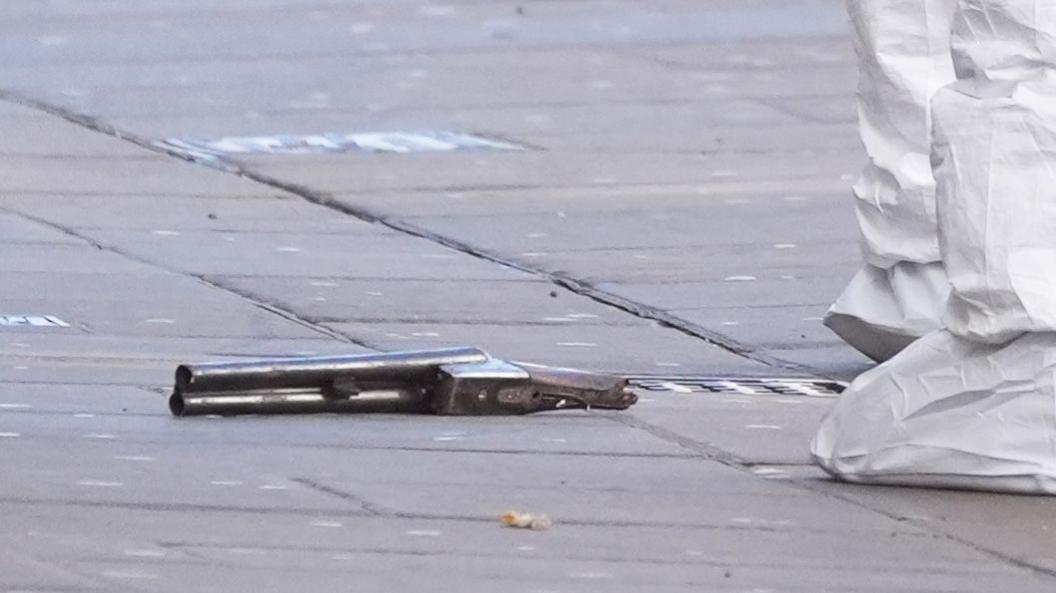 A short-barrelled shot gun on the floor