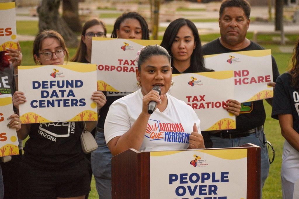 Stephanie Maldonado, the political director of LUCHA, speaks at a rally to stop data centres. She is surrounded by protestors holding signs that say "defund data centres"