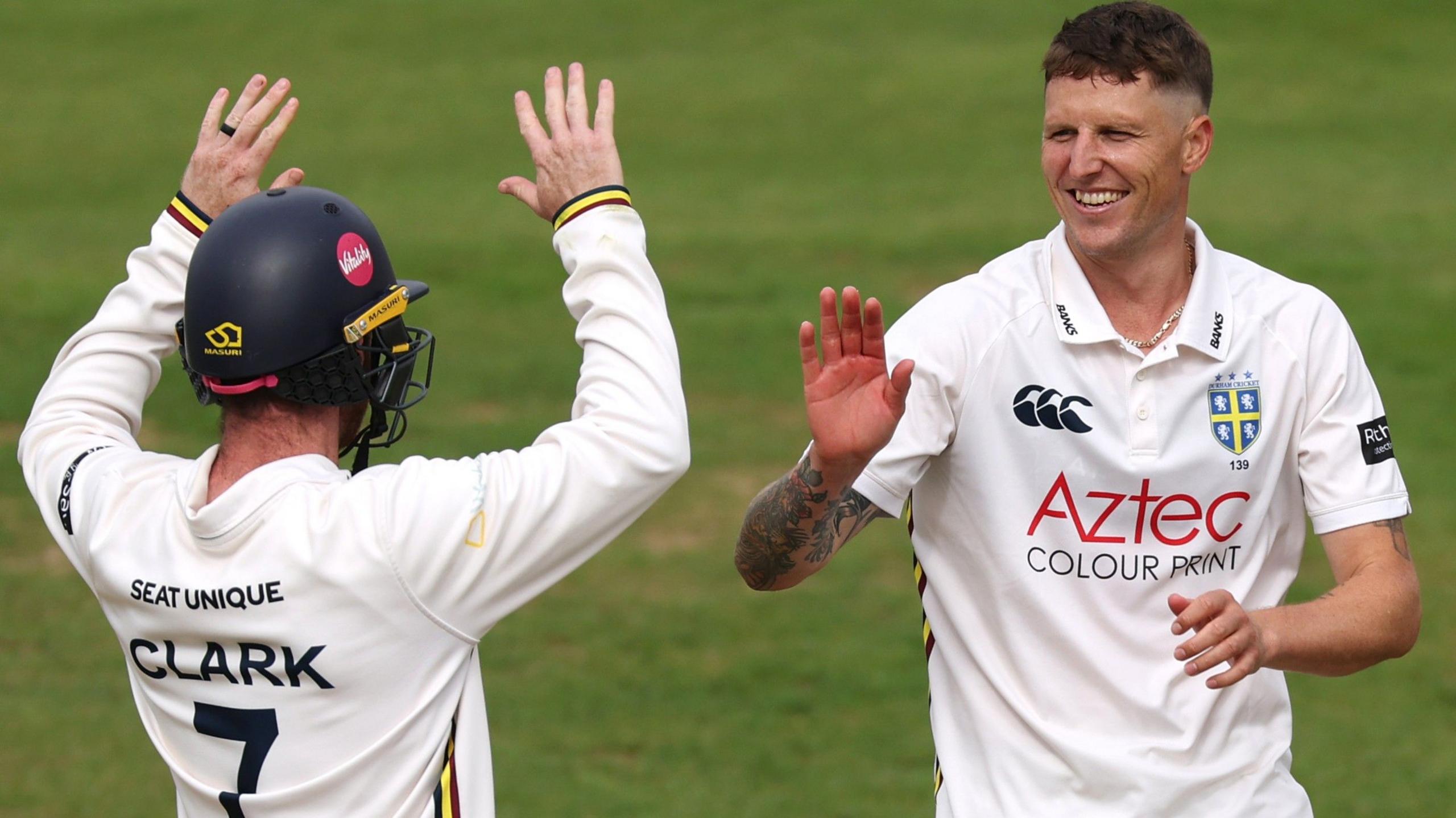 Brydon Carse high-fives a Durham team-mate