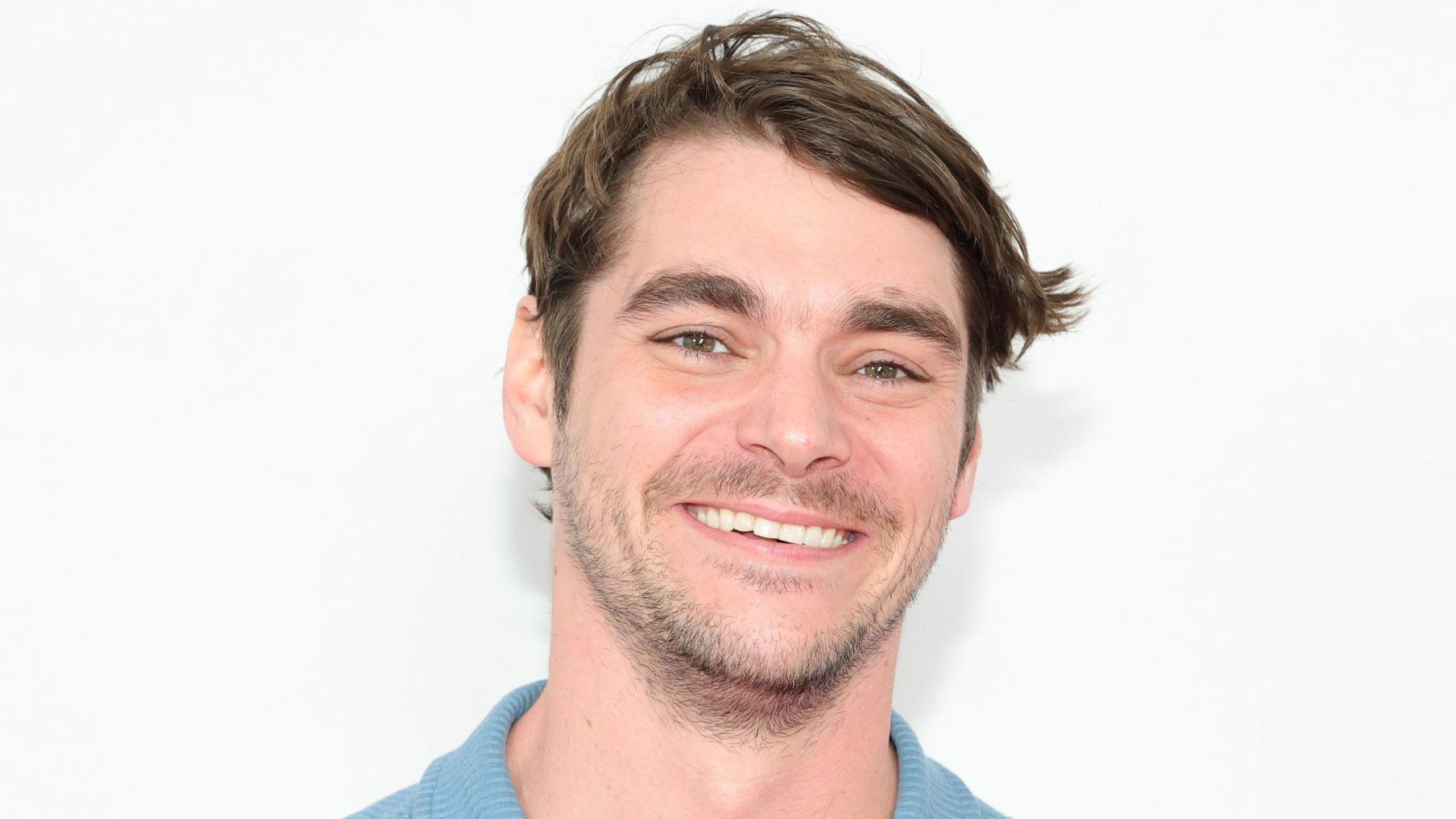 RJ Mitte smiling and wearing a blue top