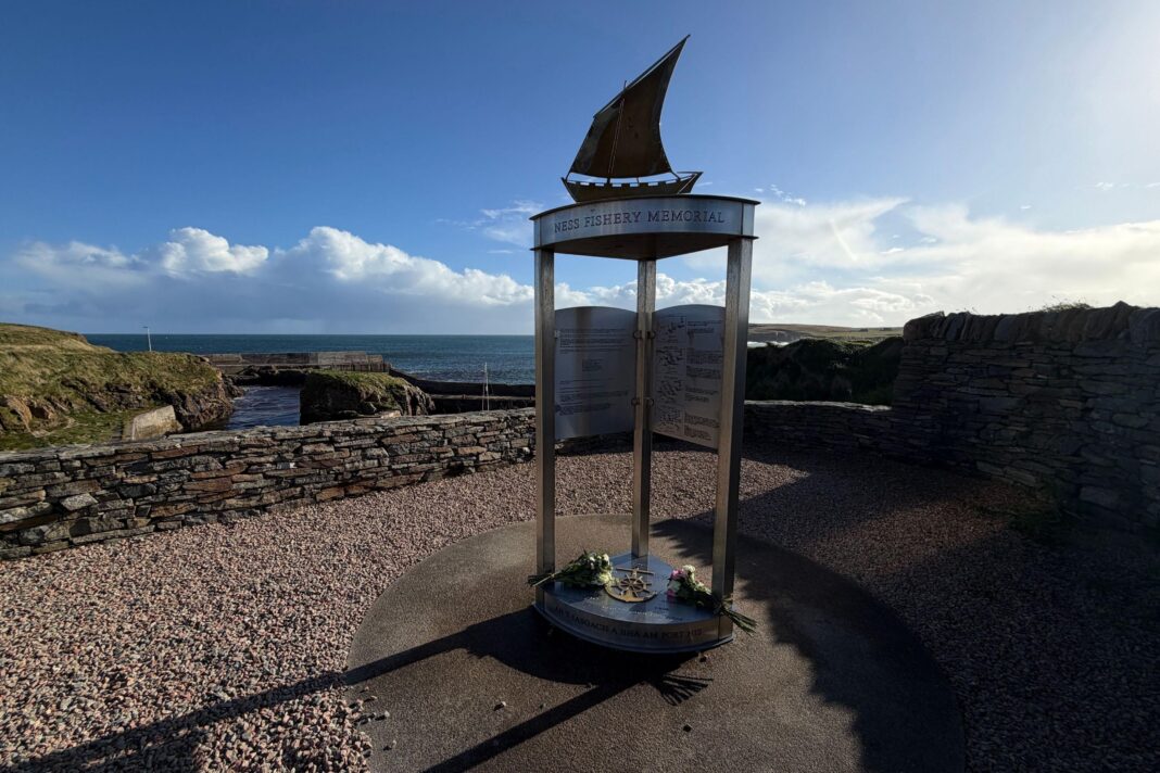 Crew in Lewis fishing boat tragedy named by police The memorial is a tall metal structure with a plinth and three narrow legs holding an upper section with the sculpture of a fishing boat with a sail. The memorial is in a gravel-covered area at the harbour at Port of Ness.