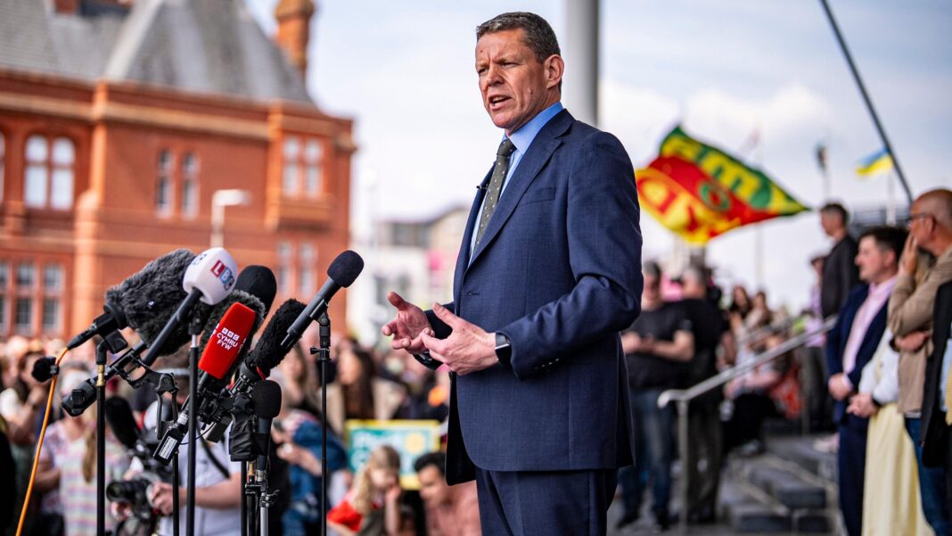 The image shows Rhun ap Iorwerth addressing a crowd outside the Senedd following May's Senedd election result.