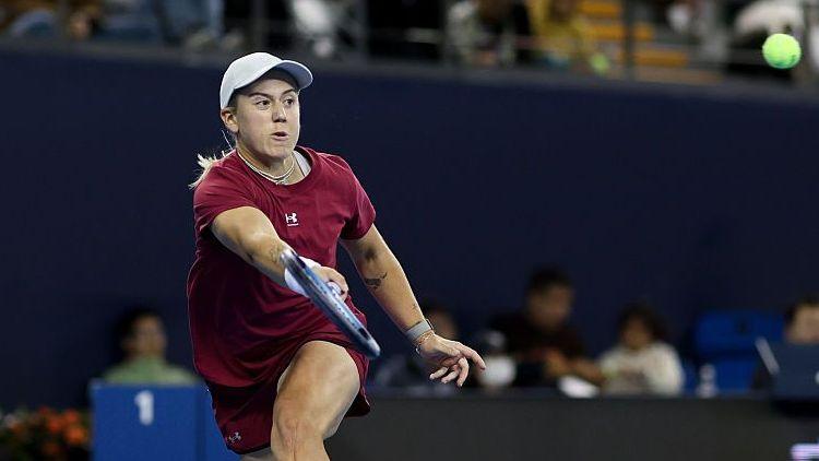 Sonay Kartal, in deep red tennis kit and white cap, plays a forehand shot at the Wuhan Open