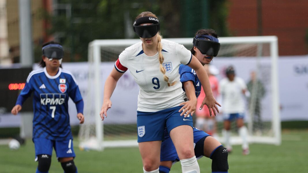 The England keeper set to face his dad at a World Cup England blind footballer Samantha Gough dribbles with the ball. She wear England kit and her blonde hair is in a plait. She wears blindfold goggles.