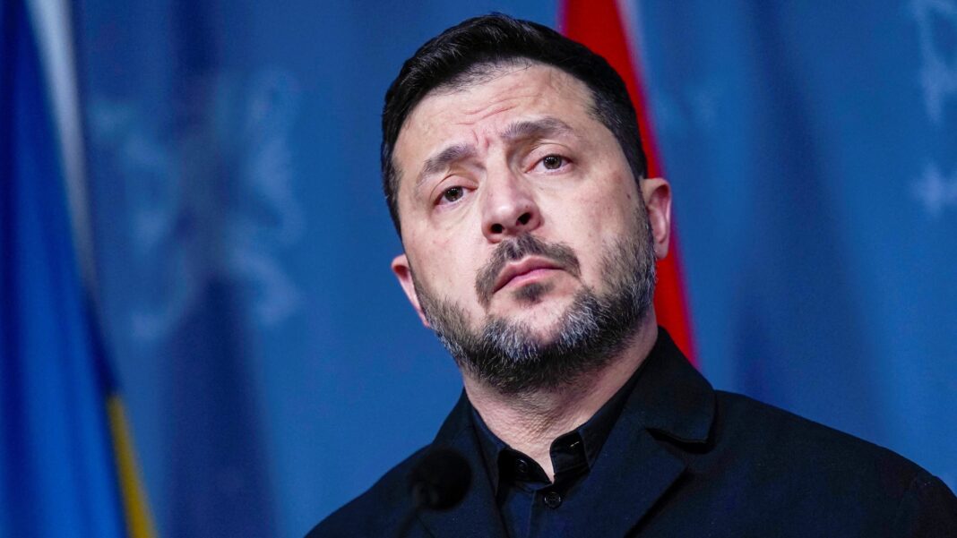 Russia frees US citizen Stephen Hubbard, state media reports Zelensky speaking in front of a blue background wearing a high-necked black top.