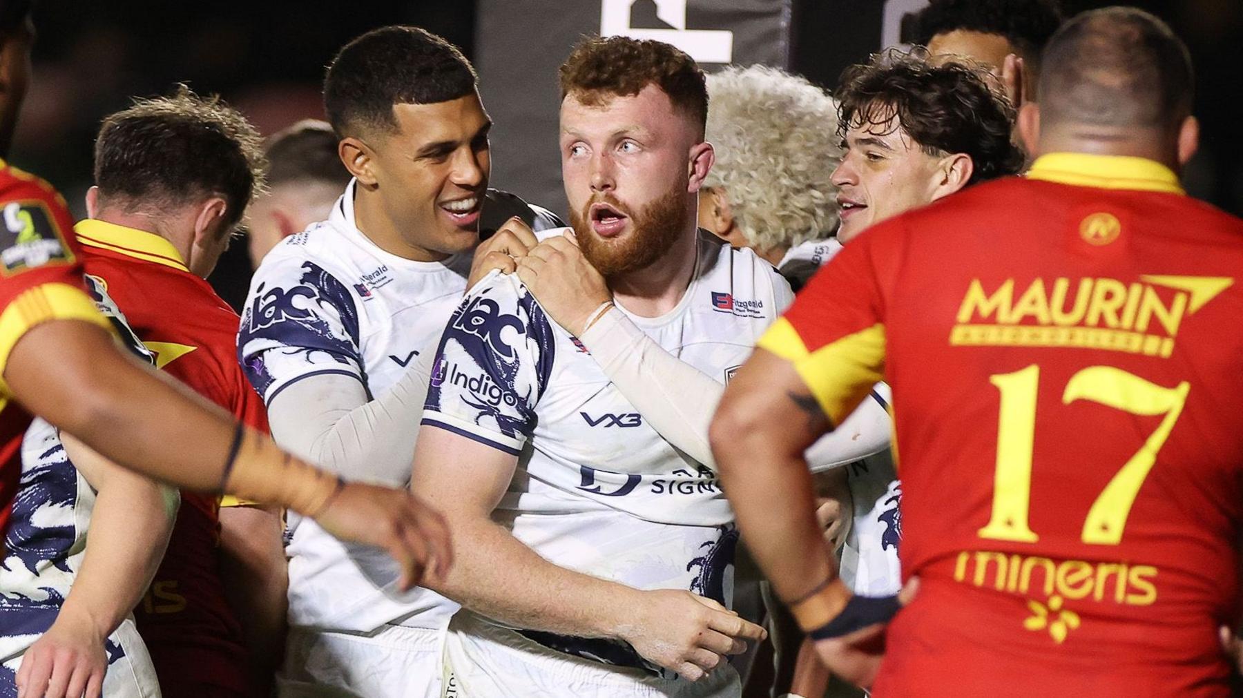 Aneurin Owen is congratulated by his Dragons team-mates after scoring a try