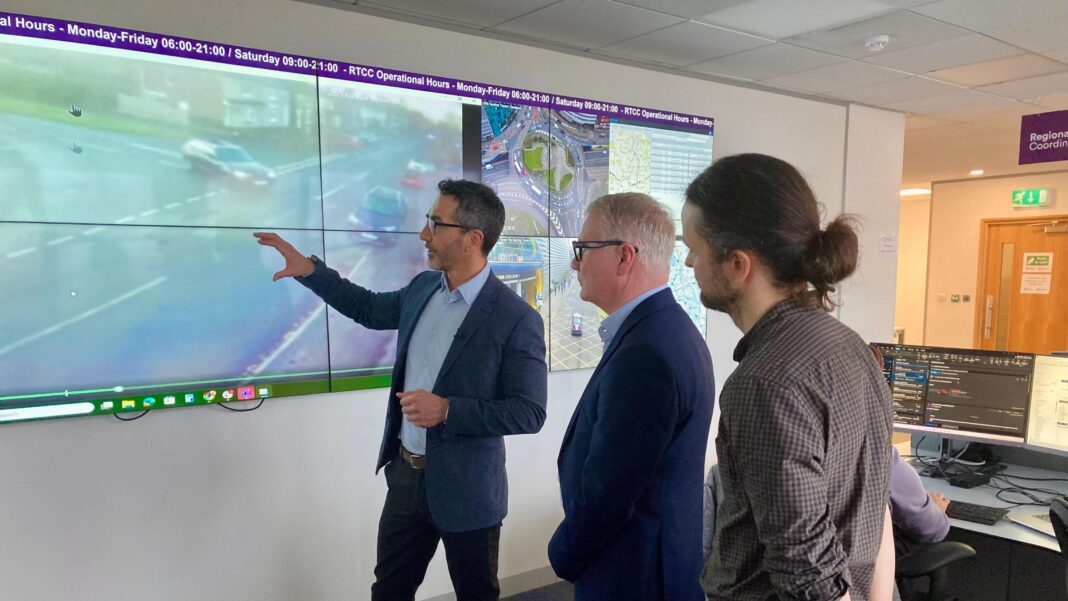 AI spots nearly 19,000 ‘shocking’ road offences Three men looking at a projection of CCTV footage of a road. They are all standing side-on and wearing business wear. The CCTV footage illustrates a car pulling out of a junction. They are standing in an office.