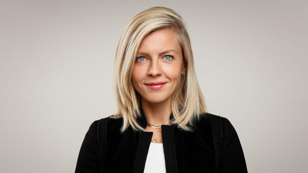 ‘We got penalised for saying ‘pregnancy’ on Instagram’ Deirdre O'Neill looks at the camera and smiles. She has blonde hair, blue eyes, and is wearing a black jacket and white blouse. She's standing against a plain grey backdrop.