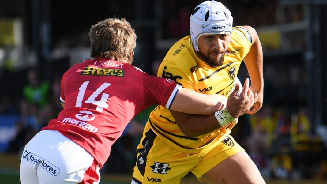 Dragons wing Anzelo Tuitavuki is tackled by Scarlet wing Ellis Mee who is wearing the number 14 jersey