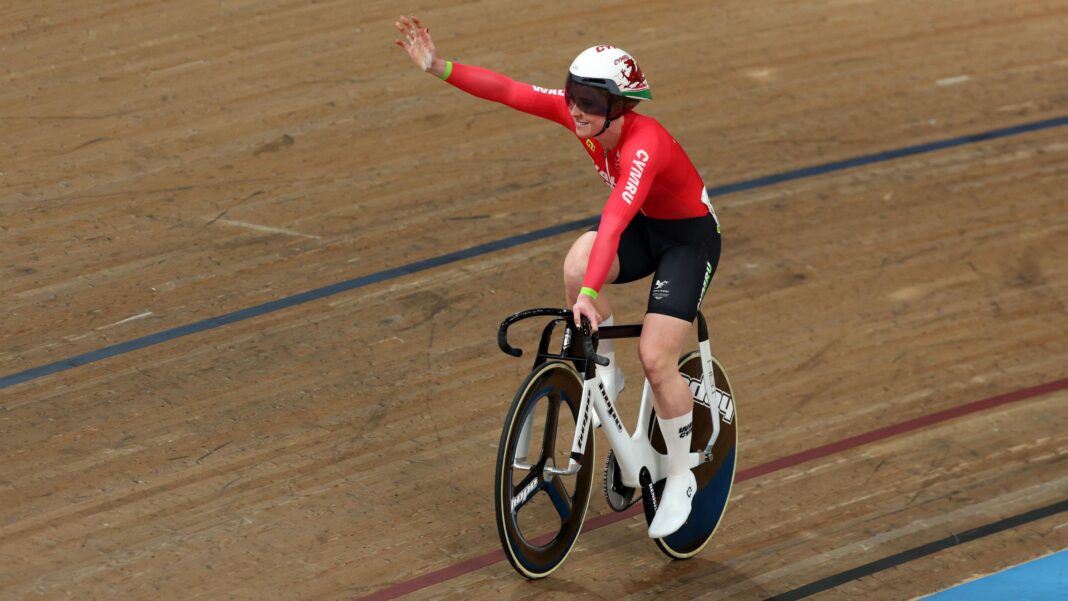 Hunt and Hodgkinson inspire Finucane’s gold hunt – watch World Championships on BBC Emma Finucane of Team Wales in red and black waves while riding a balck and white bike a velodrome track