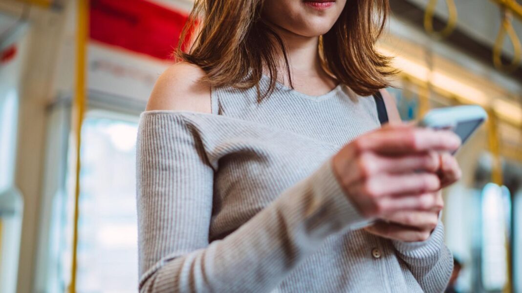 People playing loud music on buses could face £100 fine A woman holding a smartphone on a bus