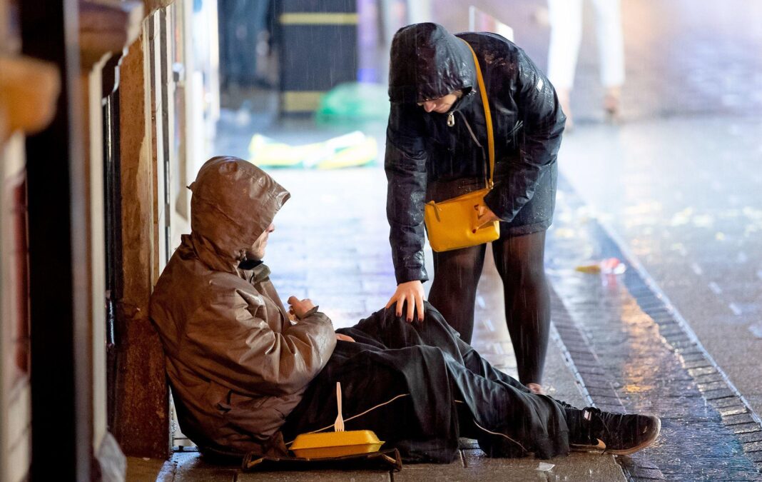 Funding set to double for plan to get rough sleepers off streets by Christmas A passer by touches the knee of a homeless person sitting on the floor on a street as they check in with them, both hooded on a rainy day in Cardiff in 2018.