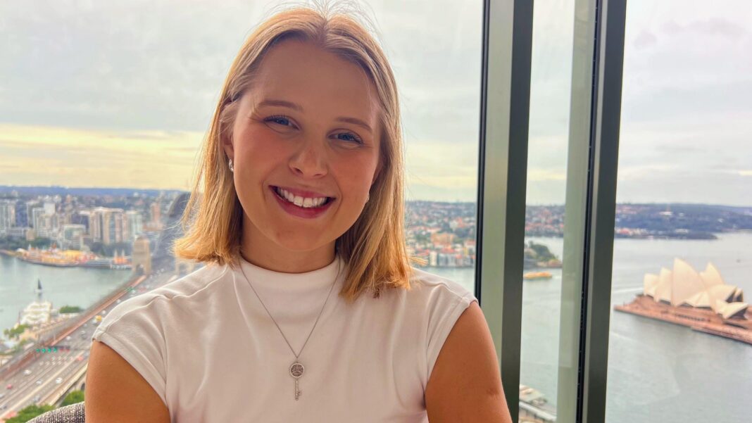 The grads ditching the UK for a fresh start abroad Rachel James stands in front of a window that looks over Sydney harbour and the Australian city's famous opera house