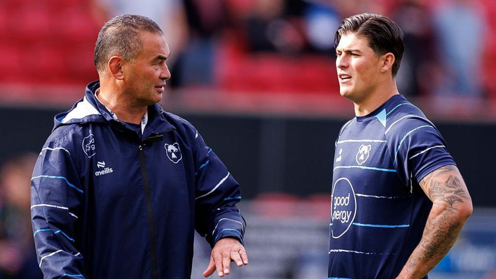 Pat Lam stands talking to Louis Rees-Zammit (right) before Bristol v Northampton