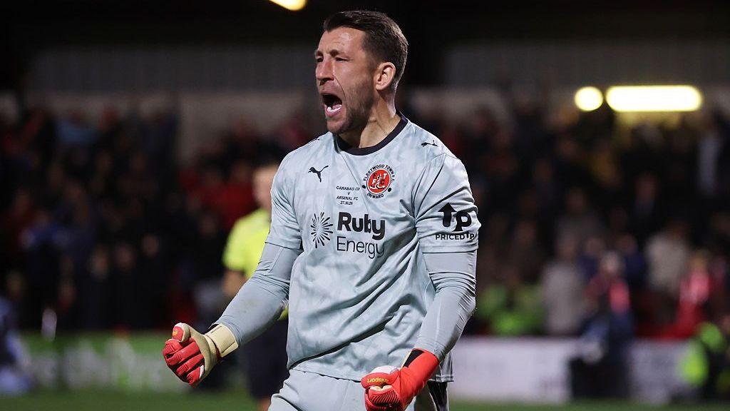 Jay Lynch of Fleetwood Town celebrates saving Arsenal's fourth penalty taken by Bruno Guimaraes in the penalty shootout during the Carabao Cup Fourth Round