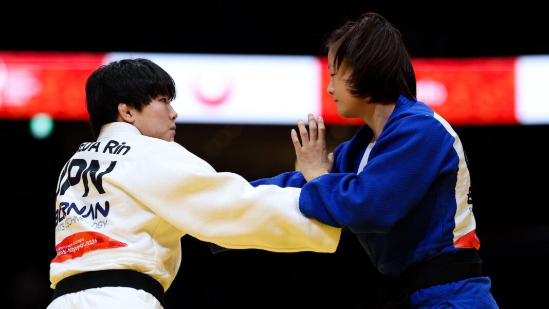 Rin Maeda, in white, grapples with Tang Jing, in blue