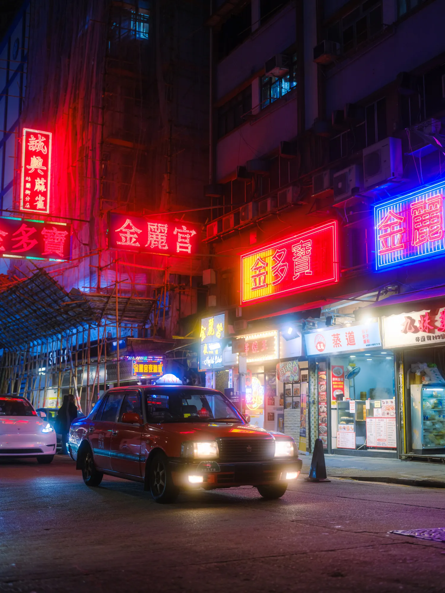 Image may contain Urban City Car Transportation Vehicle Night Life Road Street Architecture Building and Person