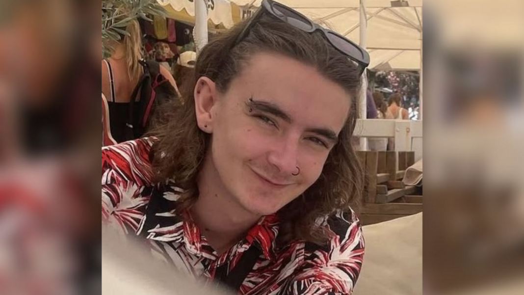 Student who stabbed housemate 30 times admits murder Jamie Collins wearing a black, red and white patterned shirt and sunglasses on his head. He has shoulder length brown hair and piercings in his ears, eyebrow and nose. He appears to be sitting underneath a white marquee on a sunny day.