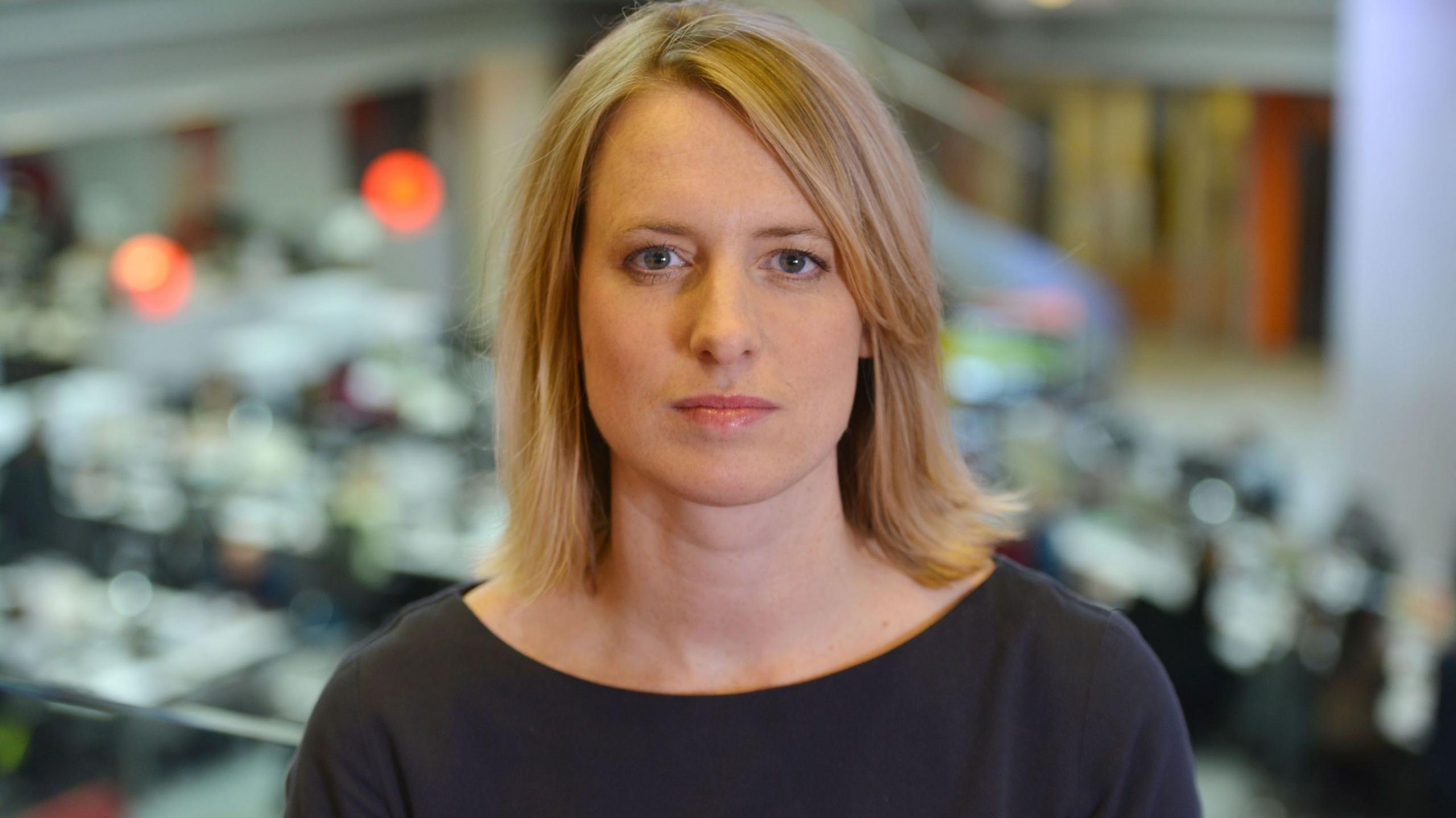 Rachel Jupp pictured against the backdrop of the news room in New Broadcasting House