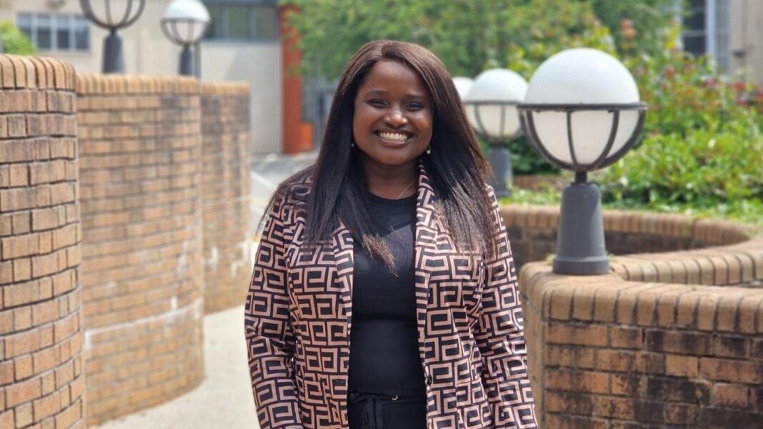 Daughter wins £127k claim for caring for mum at home Louise is smiling at the camera. She has dark brown hair and is wearing a jacket with a black and orange square-like pattern.