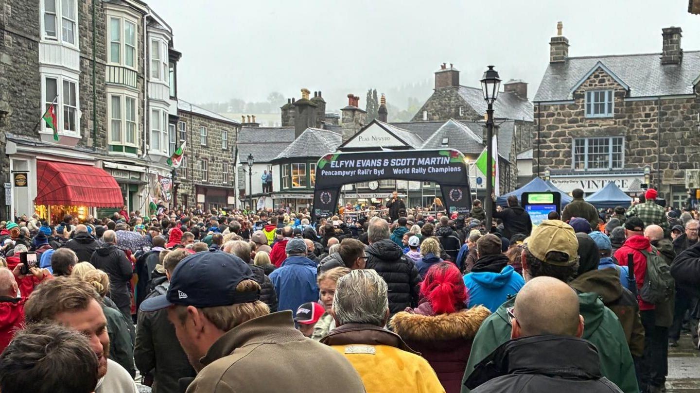 A crowd of people facing a stage, taken from behind.