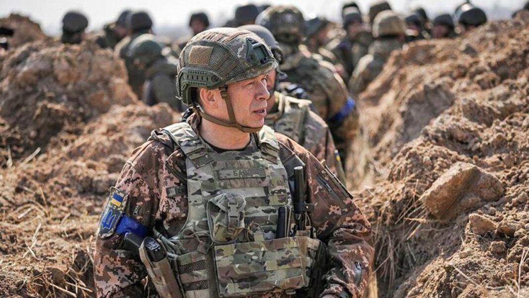 Russian strikes leave 600,000 without power in Ukraine, Zelensky says Gen Oleksandr Syrskyi walks in a trench in front of other soldiers.