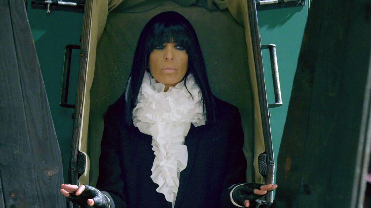 Claudia Winkleman emerging from a coffin
