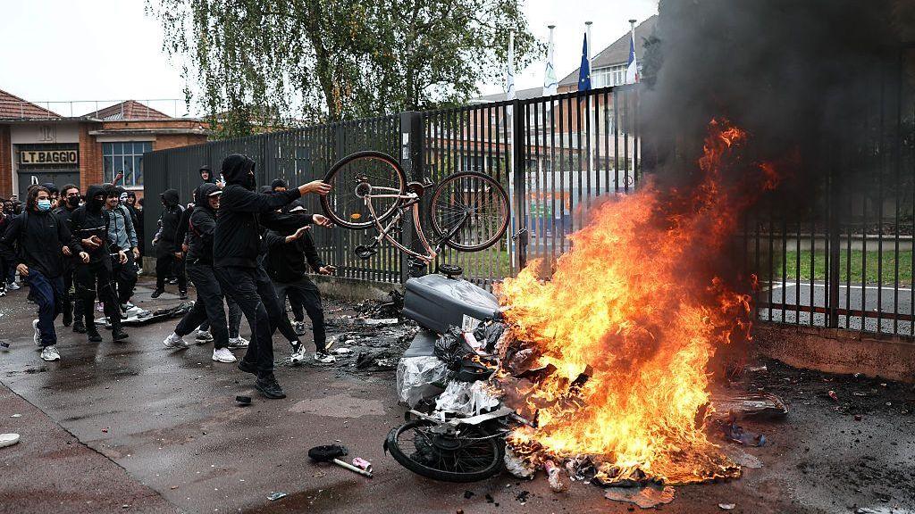 Black smoke billows from burning bins and bicycles as students carry out a blocking protest at the Cesar Baggio secondary school during a day of nationwide public sector strikes and demonstrations, in Lille, on September 29, 2026.