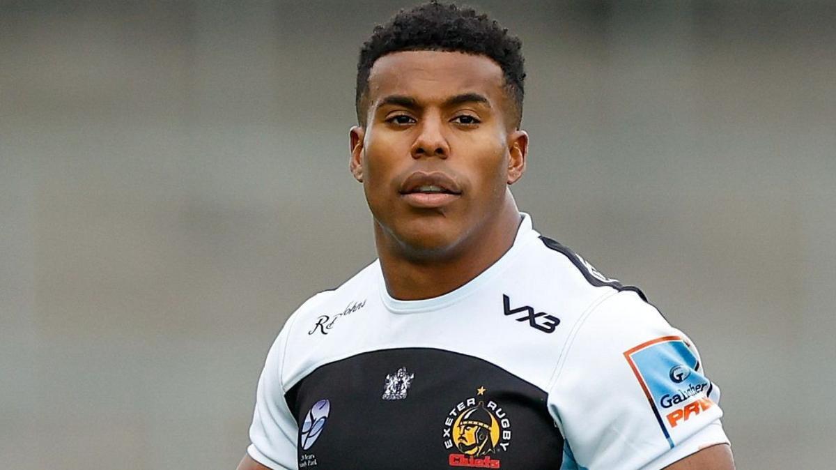 Head and shoulders view of Immanuel Feyi-Waboso, wearing Exeter's largely white and black kit
