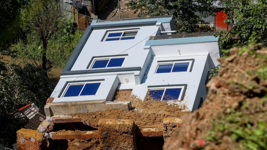 Many Nepalis swept away in the floods aren’t officially dead, leaving families in limbo A damaged house is swept away by a landslide following heavy rains in Dhapakhel, Lalitpur, Nepal