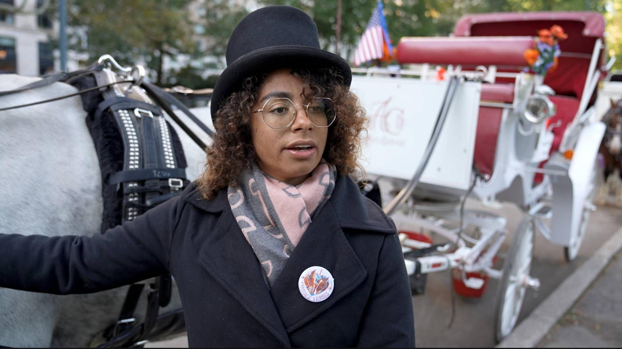 Alexus Lawson poses next to her horse-drawn carriage