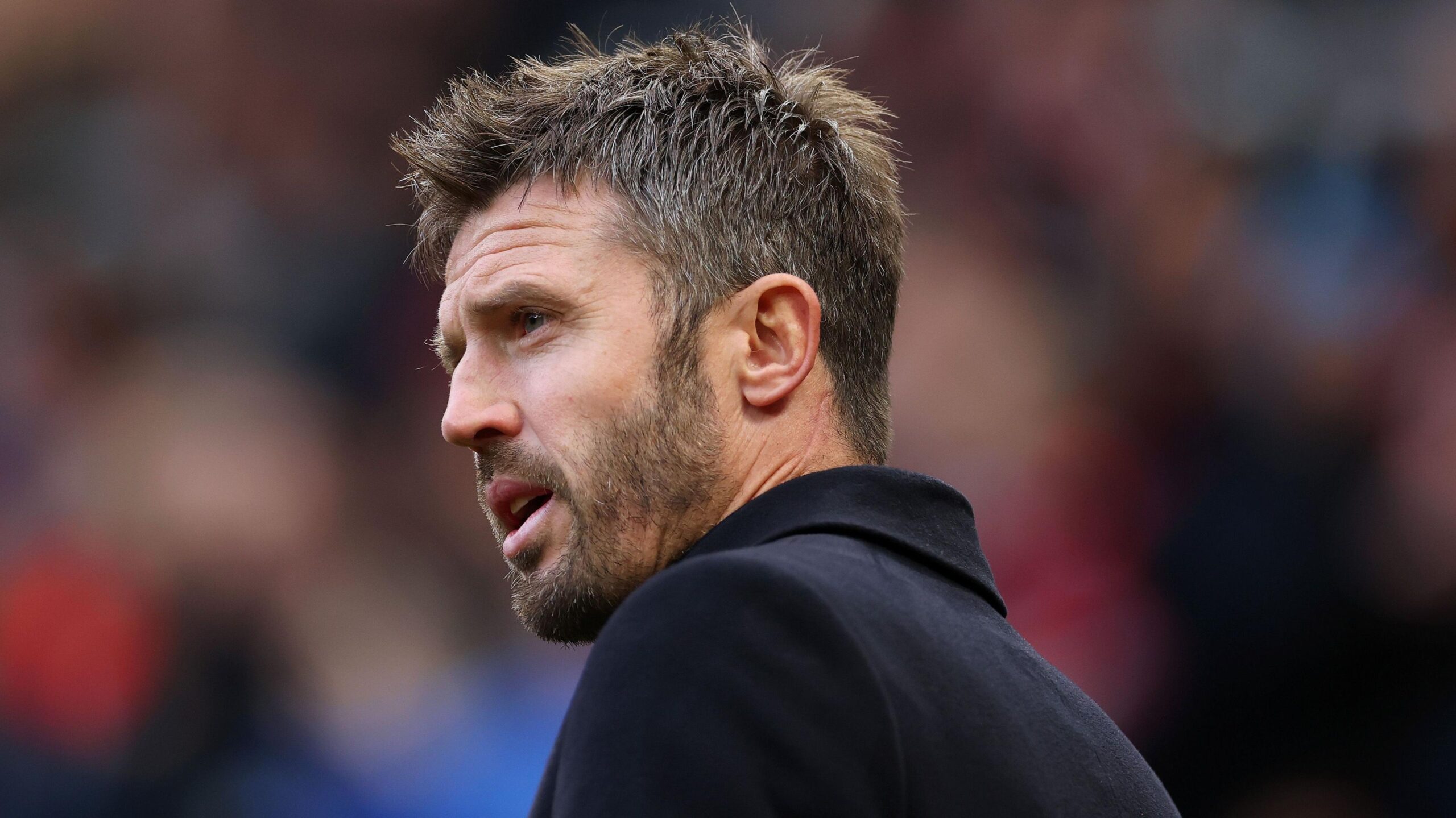 Head and shoulders side view of Manchester United manager Michael Carrick, who is wearing a dark coat