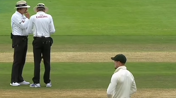 The umpires inspect the ball as Cameron Bancroft looks on