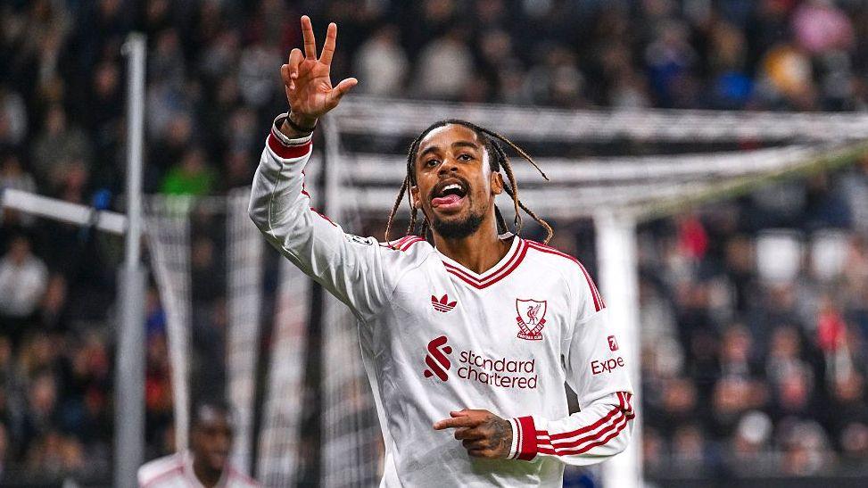Bradley Barcola, wearing Liverpool's white away kit, holds up three fingers after scoring a hat-trick against LASK in the Champions League